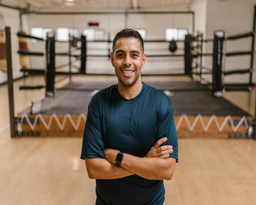 Male trainer smiling in gym setting